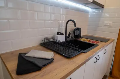 a kitchen counter with a sink and a keyboard at Lux Apartman Sunce in Jagodina