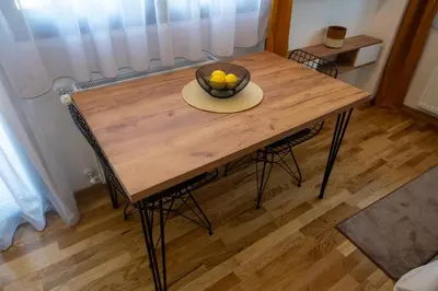 a wooden table with a bowl of fruit on it at Lux Apartman Sunce in Jagodina