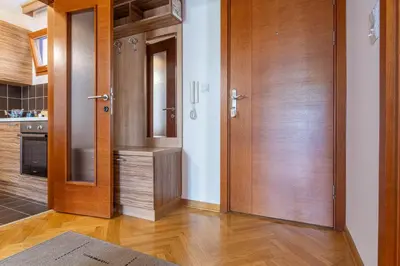 a kitchen with wooden doors and wooden floors at Duma Apartmani Vrnjačka Banja in Vrnjci