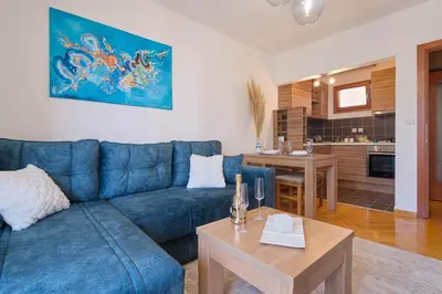 a living room with a blue couch and a table at Duma Apartmani Vrnjačka Banja in Vrnjci