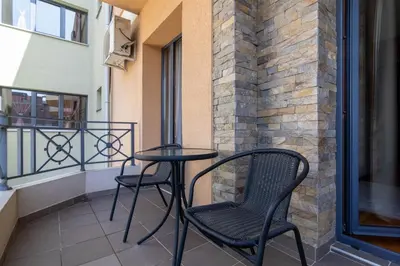 a table and two chairs on a balcony at Duma Apartmani Vrnjačka Banja in Vrnjci