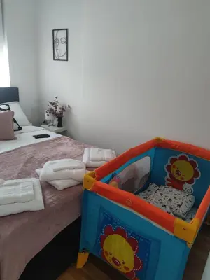 a bedroom with a bed with a toy crib at Apartman Dunjic in Vrnjačka Banja