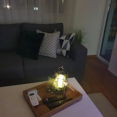 a living room with a couch and a table with a lamp at Apartman Dunjic in Vrnjačka Banja