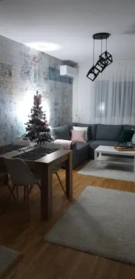 a living room with a christmas tree on a table at Apartman Dunjic in Vrnjačka Banja