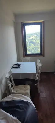 a room with a table and chairs and a window at Vidik suite in Kopaonik