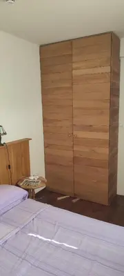 a bedroom with a bed and a large wooden cabinet at Vidik suite in Kopaonik