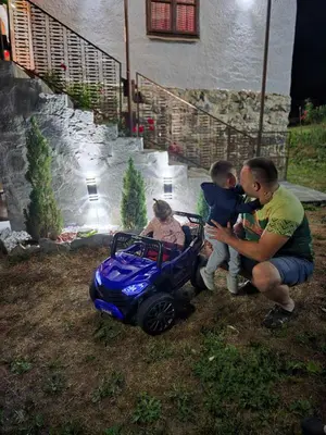 a man and a boy playing with a toy car at Kmetova Bajka in Janja