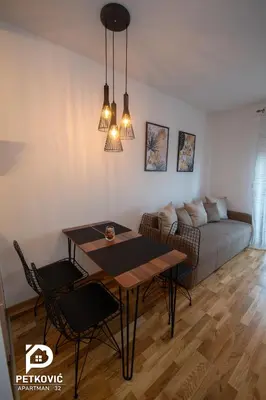 a living room with a table and a couch at Petković apartmani STUDIO32 in Jagodina