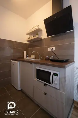 a kitchen with a sink and a microwave at Petković apartmani STUDIO32 in Jagodina