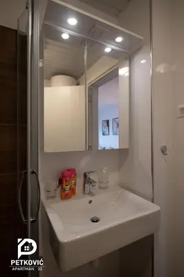 a bathroom with a white sink and a mirror at Petković apartmani STUDIO32 in Jagodina