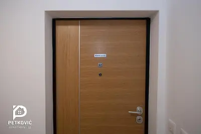 a wooden elevator door in a room at Petković apartmani STUDIO32 in Jagodina