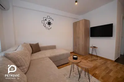 a living room with a couch and a flat screen tv at Petković apartmani STUDIO32 in Jagodina