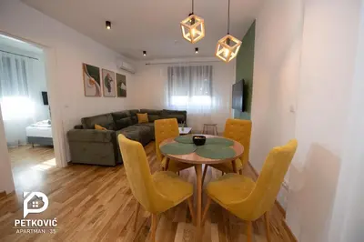 a living room with a table and chairs and a couch at Petković apartmani 35 in Jagodina