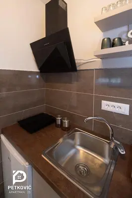 a kitchen counter with a stainless steel sink at Petković apartmani 35 in Jagodina