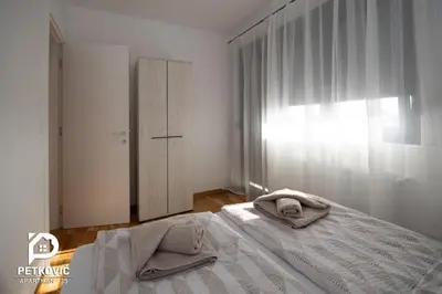 a bedroom with a bed with towels on it at Petković apartmani 35 in Jagodina