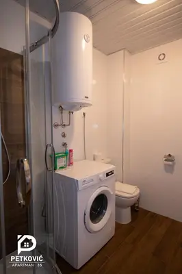 a bathroom with a washing machine and a toilet at Petković apartmani 35 in Jagodina