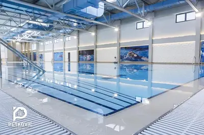 a swimming pool in a large room with water at Petković apartmani 35 in Jagodina