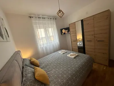 a bedroom with a bed and a couch at Apartman Pavlović in Soko Banja