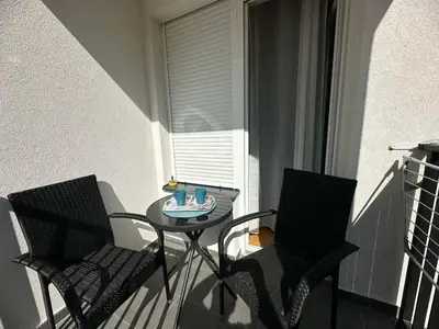 a small balcony with a table and two chairs at Apartman Pavlović in Soko Banja