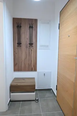 a room with a wooden bench and a door at Cozy and Lovely Apartments I & II in Jagodina