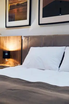 a bedroom with a bed and two pictures on the wall at Cozy and Lovely Apartments I & II in Jagodina