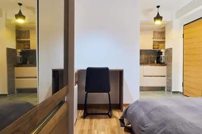 a bedroom with a desk and a chair next to a bed at Cozy and Lovely Apartments I & II in Jagodina