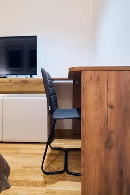 a chair sitting at a desk with a television at Cozy and Lovely Apartments I & II in Jagodina