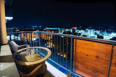 a balcony with a table and a view of a city at Cozy and Lovely Apartments I & II in Jagodina