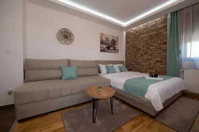 a living room with a bed and a couch at Lux Apartman Petrovic in Jagodina