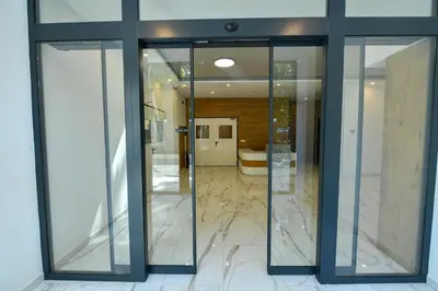 a lobby with glass doors and marble floors at Lux Apartman Petrovic in Jagodina