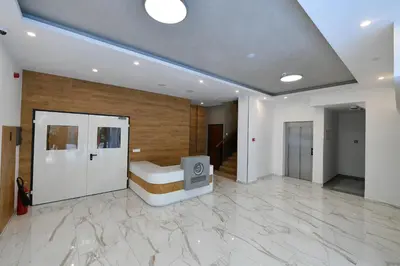 a large room with a stone floor and a room with a couch at Lux Apartman Petrovic in Jagodina