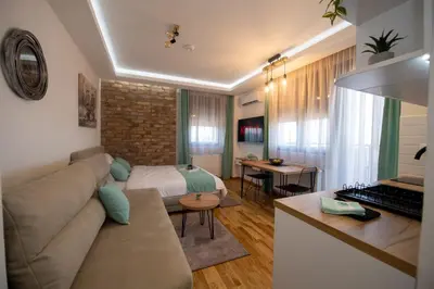 a living room with a couch and a bed at Lux Apartman Petrovic in Jagodina