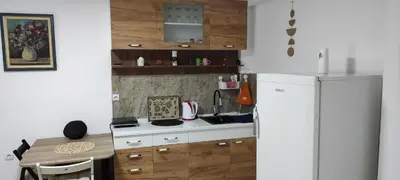 a kitchen with a white refrigerator and a table at Apartmani Simić in Kuršumlija