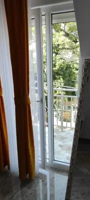 a mirror in front of a sliding glass door at Apartmani Simić in Kuršumlija