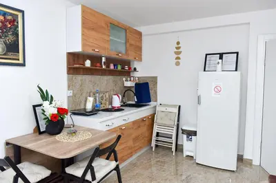 a small kitchen with a table and a refrigerator at Apartmani Simić in Kuršumlija