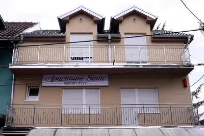 a building with a balcony on the side of it at Apartmani Simić in Kuršumlija