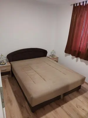 a bed in a room with two night stands at Apartment Vojinović in Soko Banja
