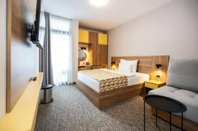 a hotel room with a bed and a couch at Planinka in Kursumlijska Banja