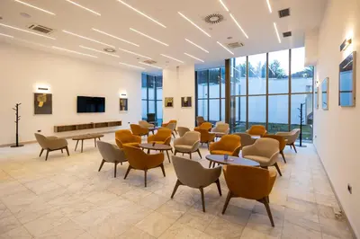 a waiting room with tables and chairs and windows at Planinka in Kursumlijska Banja