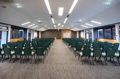 an empty room with green chairs in a classroom at Planinka in Kursumlijska Banja