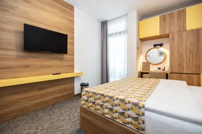 a hotel room with a bed and a flat screen tv at Planinka in Kursumlijska Banja