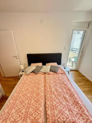 a large bed in a room with a large window at Mirabela Apartman Sokobanja in Soko Banja