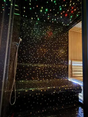 a bathroom with a shower with a bench in it at Villa Prive and Spa in Kopaonik