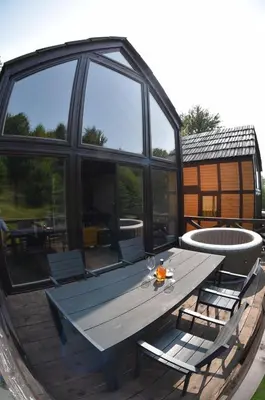 a wooden table and chairs on a patio at Villa Prive and Spa in Kopaonik