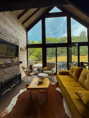 a living room with a couch and a large window at Villa Prive and Spa in Kopaonik