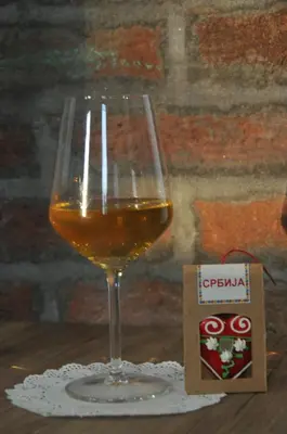 a glass of wine sitting on top of a table at Domaćinstvo Ukusno Marković in Brusnik