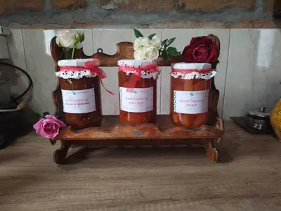 three jars of honey with flowers in them on a table at Domaćinstvo Ukusno Marković in Brusnik