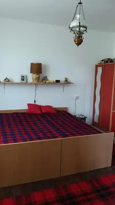 a bedroom with a large bed with a red and blue at Domaćinstvo Ukusno Marković in Brusnik