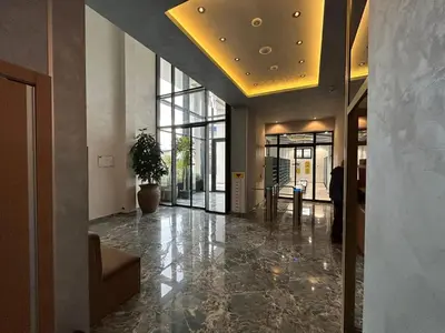 an office lobby with a hallway with a potted plant at Orca Apartman in Jagodina