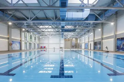 a large swimming pool with blue water at Orca Apartman in Jagodina